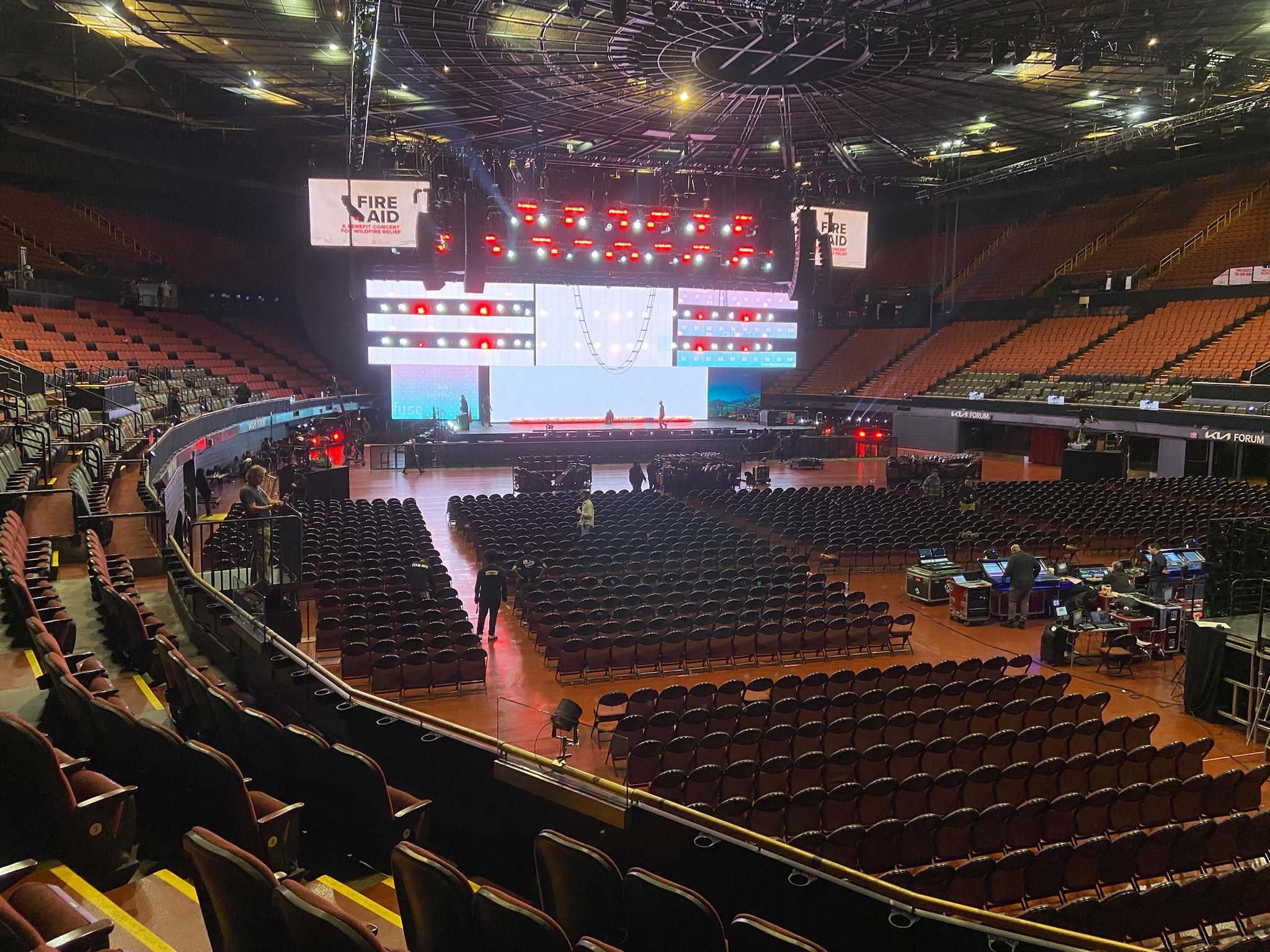 FireAid 2025 — wide empty Kia Forum before doors opened, FireAid branding visible on stage